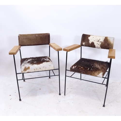 2257 - A pair of contemporary design cowhide upholstered elbow chairs, on black tubular metal frame