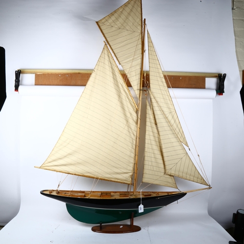 439 - A large painted wooden-hulled modern pond yacht, with sails and rigging, on fitted stand, overall he... 