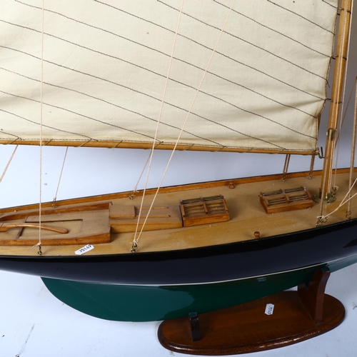 439 - A large painted wooden-hulled modern pond yacht, with sails and rigging, on fitted stand, overall he... 