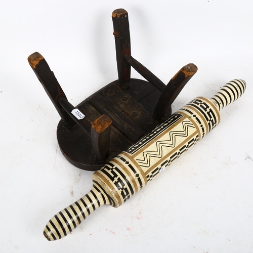 609 - A small oak milking stool, and a Folk Art rolling pin (2)