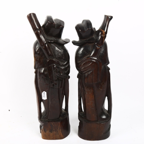 722 - A pair of carved hardwood Eastern figures with inlaid decoration, tallest 36cm