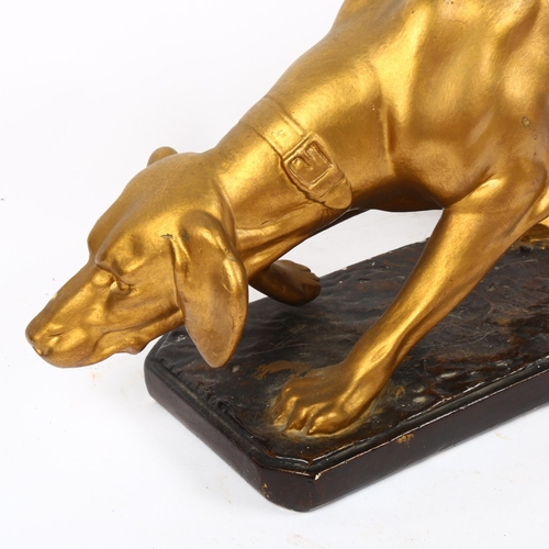 855 - A painted and gilded plaster sculpture of a hound, length 58cm