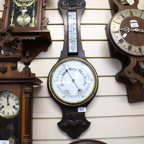 912 - Antique aneroid barometer in carved oak case, with thermometer, height 80cm