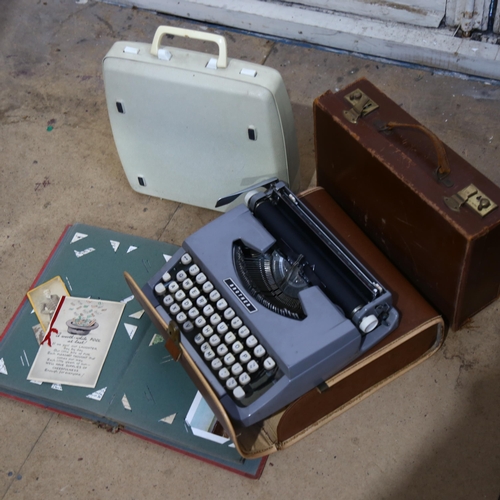 935 - A Smith Corona cased portable typewriter, another, an attache case, and an album of photos and postc... 