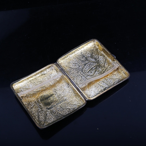 1219 - An Eastern unmarked white metal curved cigarette case, embossed and engraved decoration with gilt in... 