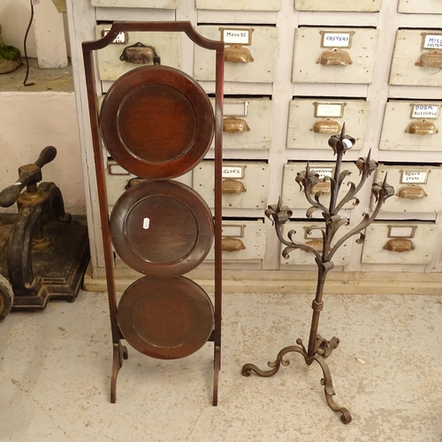 2668 - A mahogany 3-tier folding cake stand, and a wrought-iron Gothic candle stand