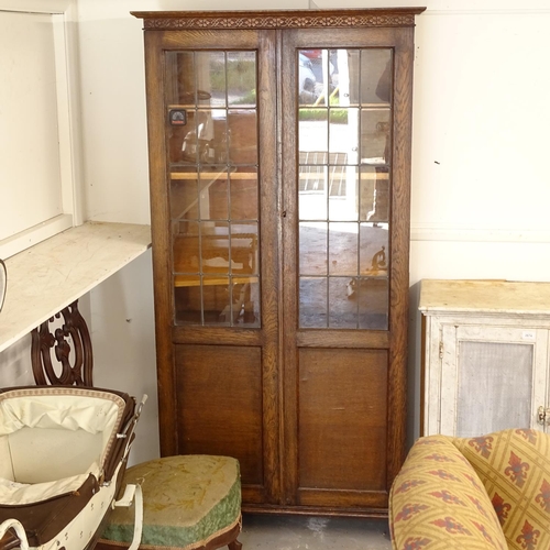 2675 - A 1920s oak bookcase, with 2 leadlight glazed and panelled doors, W92cm, H178cm, D31cm