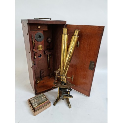 144A - A Victorian brass binocular microscope, with a box of slides and extra fittings, in original mahogan... 