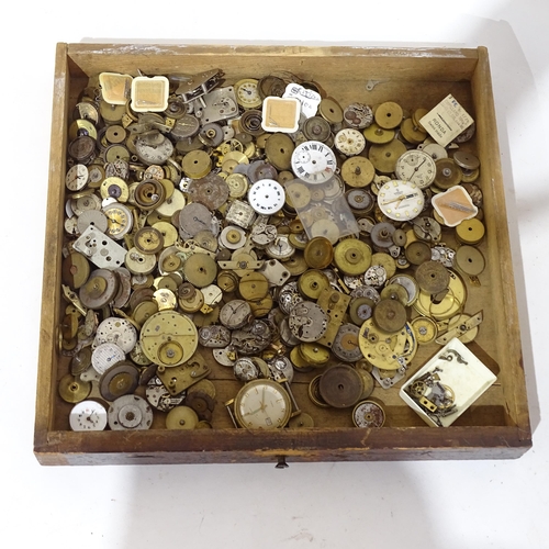 1107 - A Vintage watchmaker's table-top chest of drawers, containing a large quantity of various parts and ... 