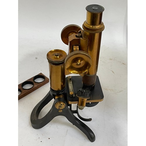 144A - A Victorian brass binocular microscope, with a box of slides and extra fittings, in original mahogan... 