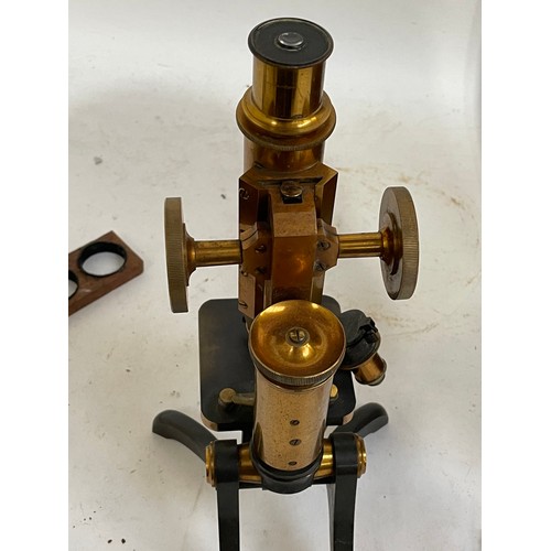 144A - A Victorian brass binocular microscope, with a box of slides and extra fittings, in original mahogan... 