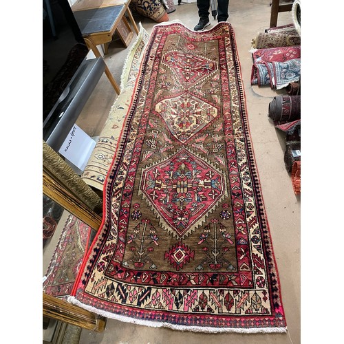 2391 - A red ground Karajeh runner, 305cm x 100cm