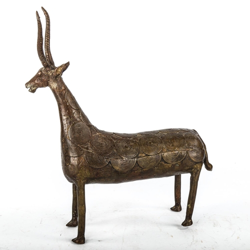 1076 - An African Tribal bronze antelope with applied disc designs to the body, overall height 34cm