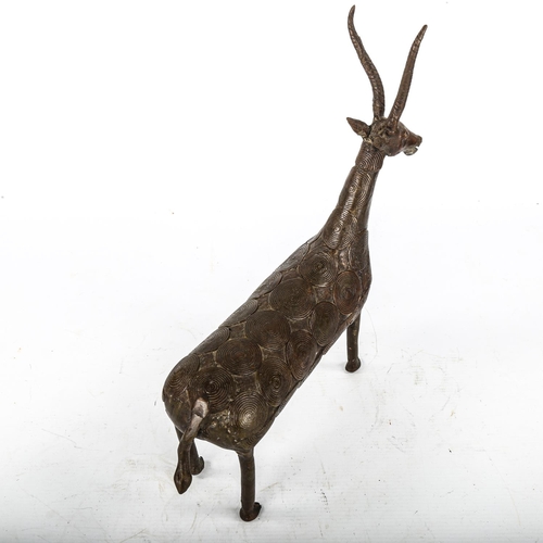 1076 - An African Tribal bronze antelope with applied disc designs to the body, overall height 34cm