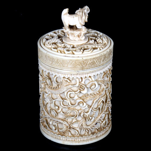 1081 - A Chinese relief carved ivory pot surmounted by a lion, height 10cm, a carved ivory Dog of Fo, and a... 