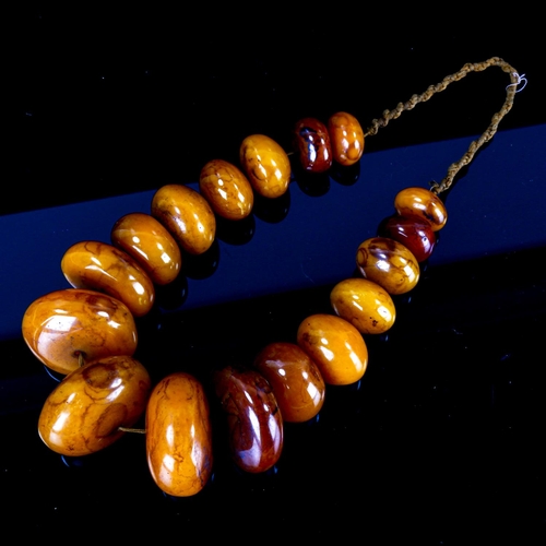 1127 - A string of large Tribal disc-shaped amber? beads, largest 6cm diameter