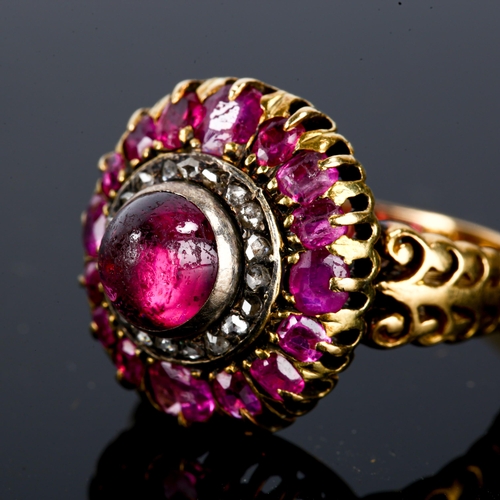 106 - An Antique ruby and diamond cluster ring, unmarked gold settings, set with central high cabochon rub... 