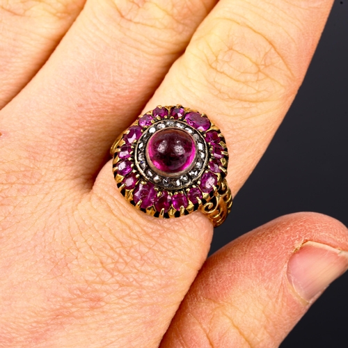 106 - An Antique ruby and diamond cluster ring, unmarked gold settings, set with central high cabochon rub... 