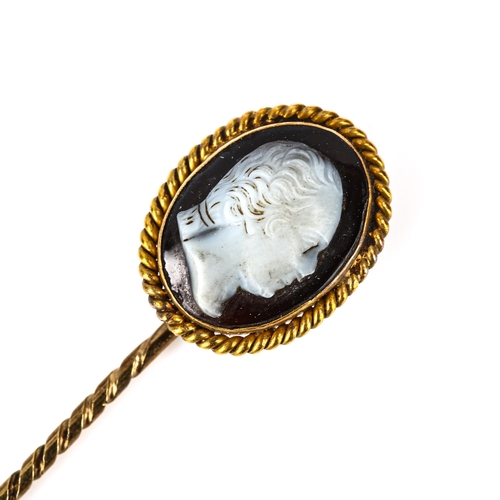 110 - An Antique hardstone cameo stickpin, unmarked gold settings, with relief carved male head profile, s... 