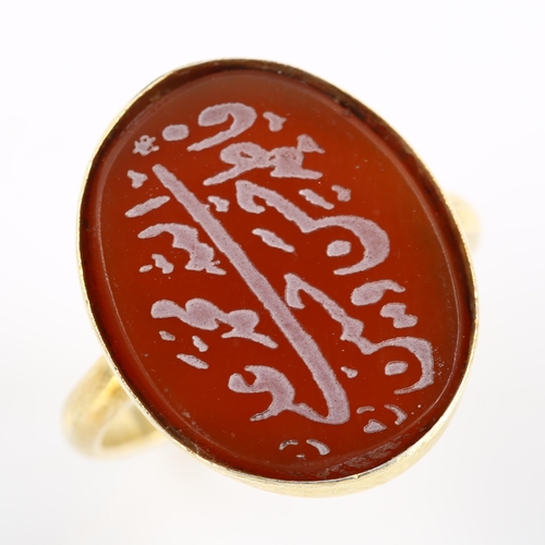 417 - An Arabic script carnelian seal ring, unmarked gilt-metal settings, setting height 20.2mm, size M, 3... 