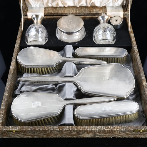 466 - A cased George VI silver dressing table set, comprising hand mirror, 2 x hair brushes, 2 x clothes b... 