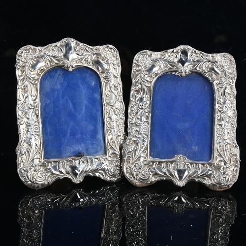 468 - A pair of Edwardian silver-fronted strut photo frames, relief embossed foliate decoration, by Sydney... 