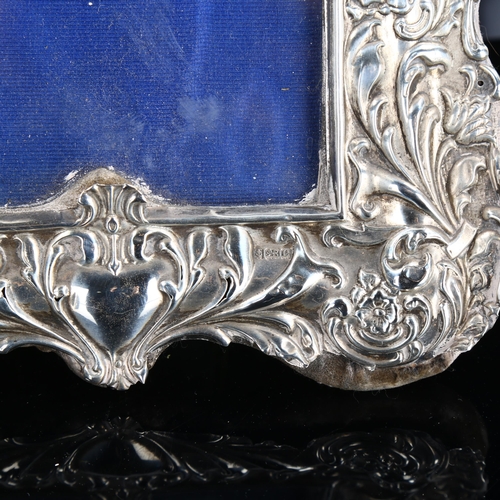 468 - A pair of Edwardian silver-fronted strut photo frames, relief embossed foliate decoration, by Sydney... 