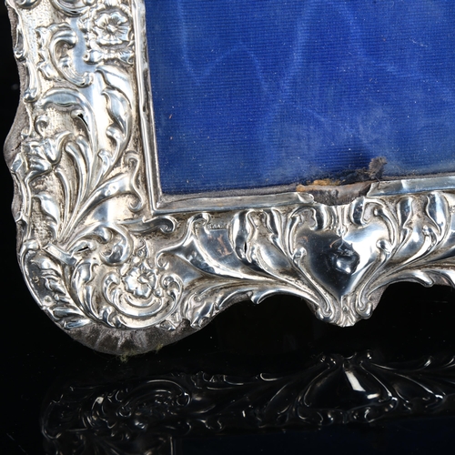 468 - A pair of Edwardian silver-fronted strut photo frames, relief embossed foliate decoration, by Sydney... 