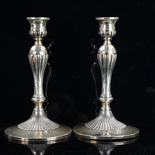 470 - A pair of Continental sterling silver table candlesticks, fluted decoration with cruciform maker's m... 