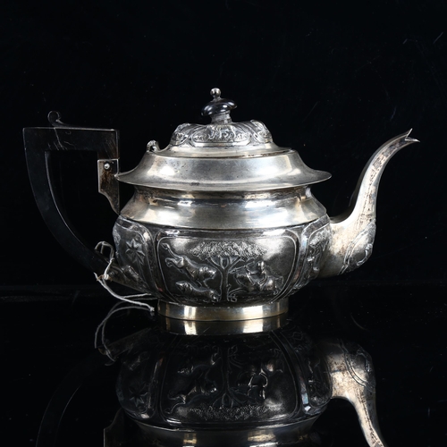 471 - An Indian unmarked silver teapot, in English taste with relief embossed hunting scenes and ebony mou... 