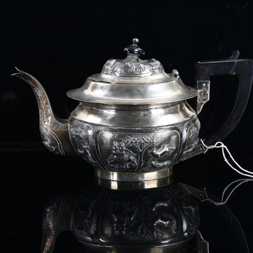 471 - An Indian unmarked silver teapot, in English taste with relief embossed hunting scenes and ebony mou... 