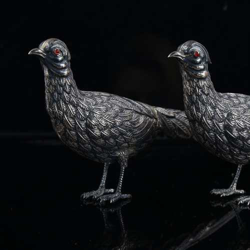 473 - A pair of Continental silver table pheasants, with cabochon red glass eyes, marks on tail feathers, ... 