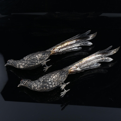 473 - A pair of Continental silver table pheasants, with cabochon red glass eyes, marks on tail feathers, ... 