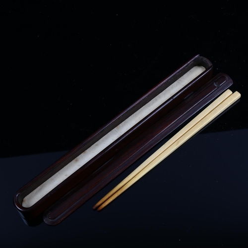 1253 - A Chinese rosewood chopstick case, length 25cm, containing a pair of ivory chopsticks