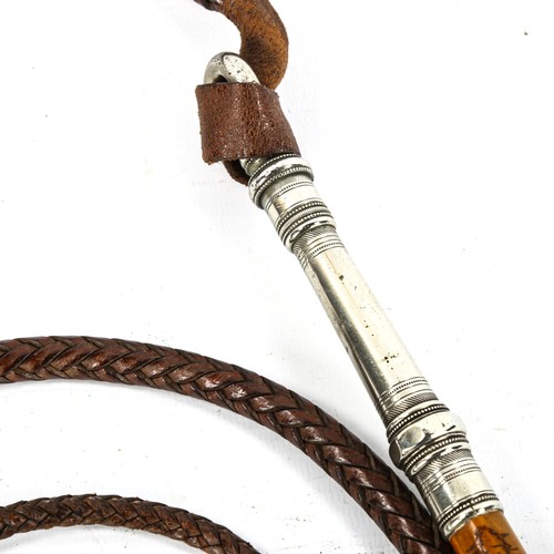 1146 - An ornate 19th century riding stock whip with woven leather thong, possibly Middle Eastern, heavy ga... 