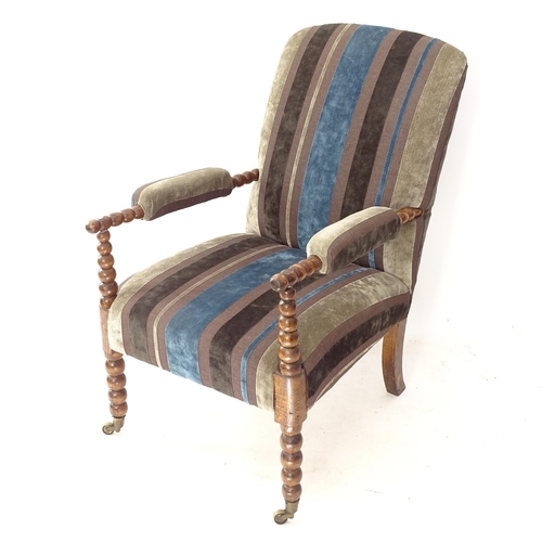 2058 - An early 20th century upholstered armchair on bobbin turned legs