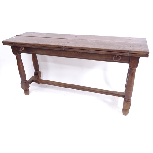 2063 - A narrow rectangular oak dining table, with double fold-out top, on H-shaped stretcher and baluster ... 