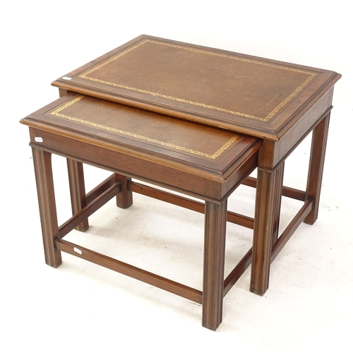 2077 - A reproduction mahogany nest of 2 occasional tables, with leather tops, widest 65cm