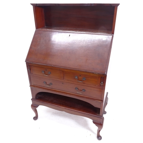 2092 - An Edwardian mahogany bureau, with shaped raised shelf, 3 long drawers and open shelf below, on cabr... 