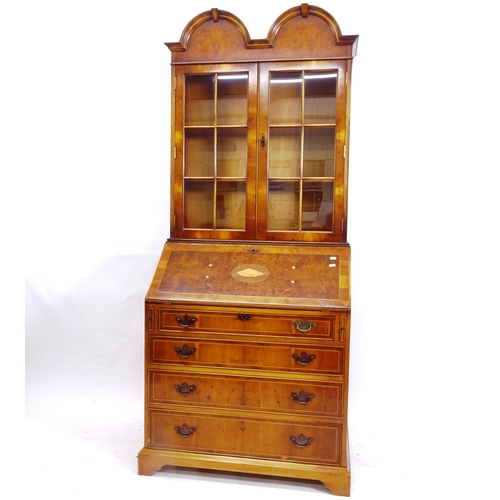 2104 - A reproduction crossbanded burr-walnut bureau bookcase, with double-dome lattice glazed top, and 4 l... 