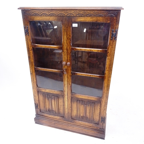 2105 - An oak bookcase with 2 glazed and linenfold panelled doors, W80cm, H121cm, D27cm