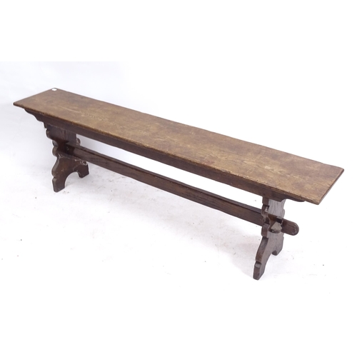 2155 - A stained oak bench on shaped ends, L153cm, H46cm, D26cm