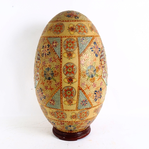 121 - A large Oriental painted and gilded porcelain egg on hardwood stand, height 50cm