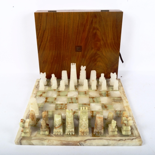 65 - A set of green and white onyx chessmen, with matching onyx chess board, 36cm x 36cm, King height 9cm... 