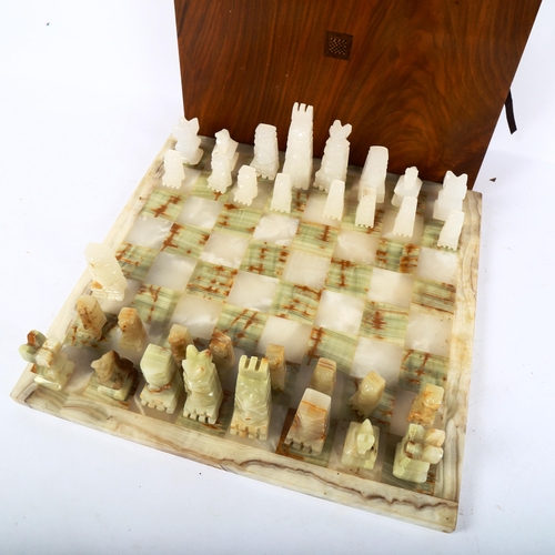 65 - A set of green and white onyx chessmen, with matching onyx chess board, 36cm x 36cm, King height 9cm... 