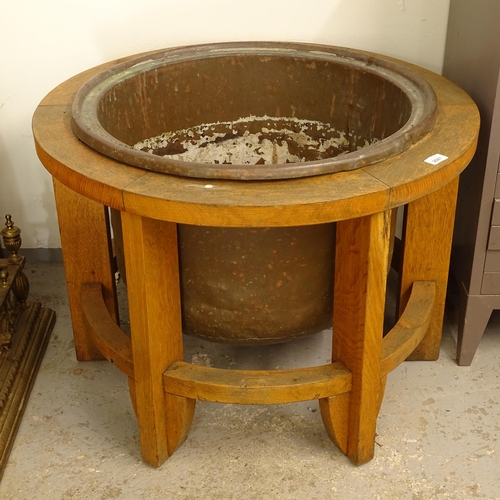 2661 - A brass planter in a circular oak stand, diameter 78cm, H57cm