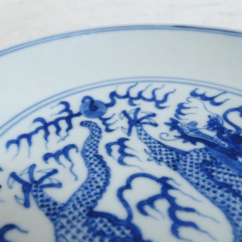 102 - A Chinese blue and white porcelain 'Dragon' plate, depicting 5-claw dragon chasing flaming pearl, 6 ... 