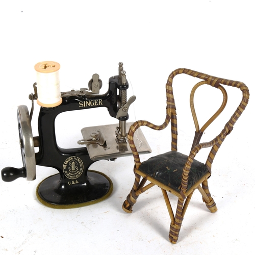 222 - A miniature cast-iron Singer sewing machine, and doll's armchair (2)