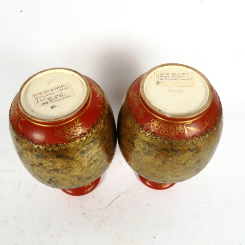 233 - A pair of Doulton painted and gilded porcelain bottle vases, height 22cm