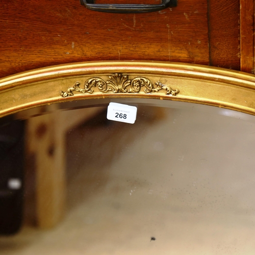 268 - A large oval gilt-framed bevel-edge wall mirror, 85cm x 60cm